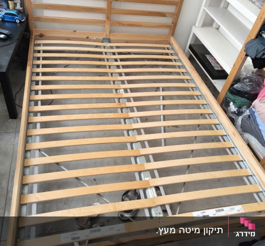 מיטה מעץ עם מסגרת מתכת בחדר שינה